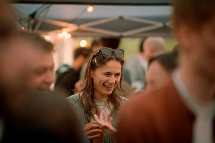 Candid shot of woman laughing at outdoor garden party in Brussels