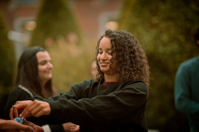 Young woman with curly hair smiling during outdoor activity