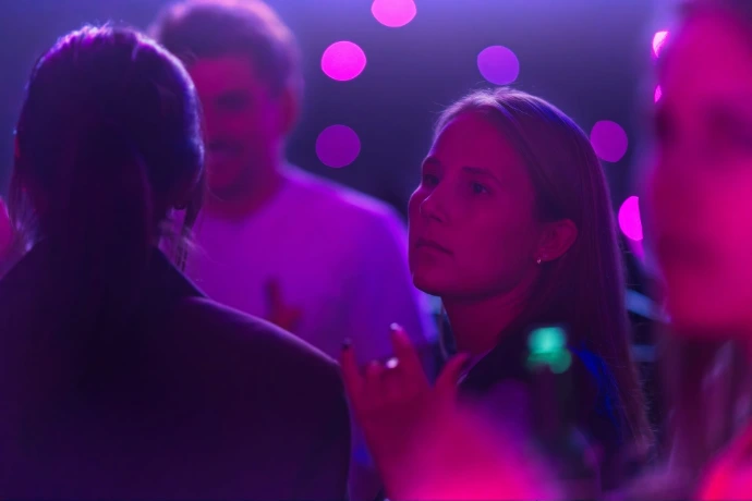 Candid portrait of woman at indoor party with purple event lighting