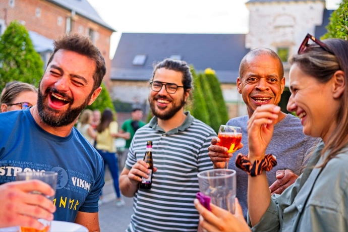 Group of friends smiling with drinks at summer party