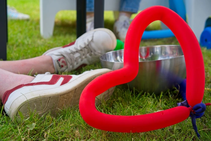 Red neon heart decoration on grass at outdoor event