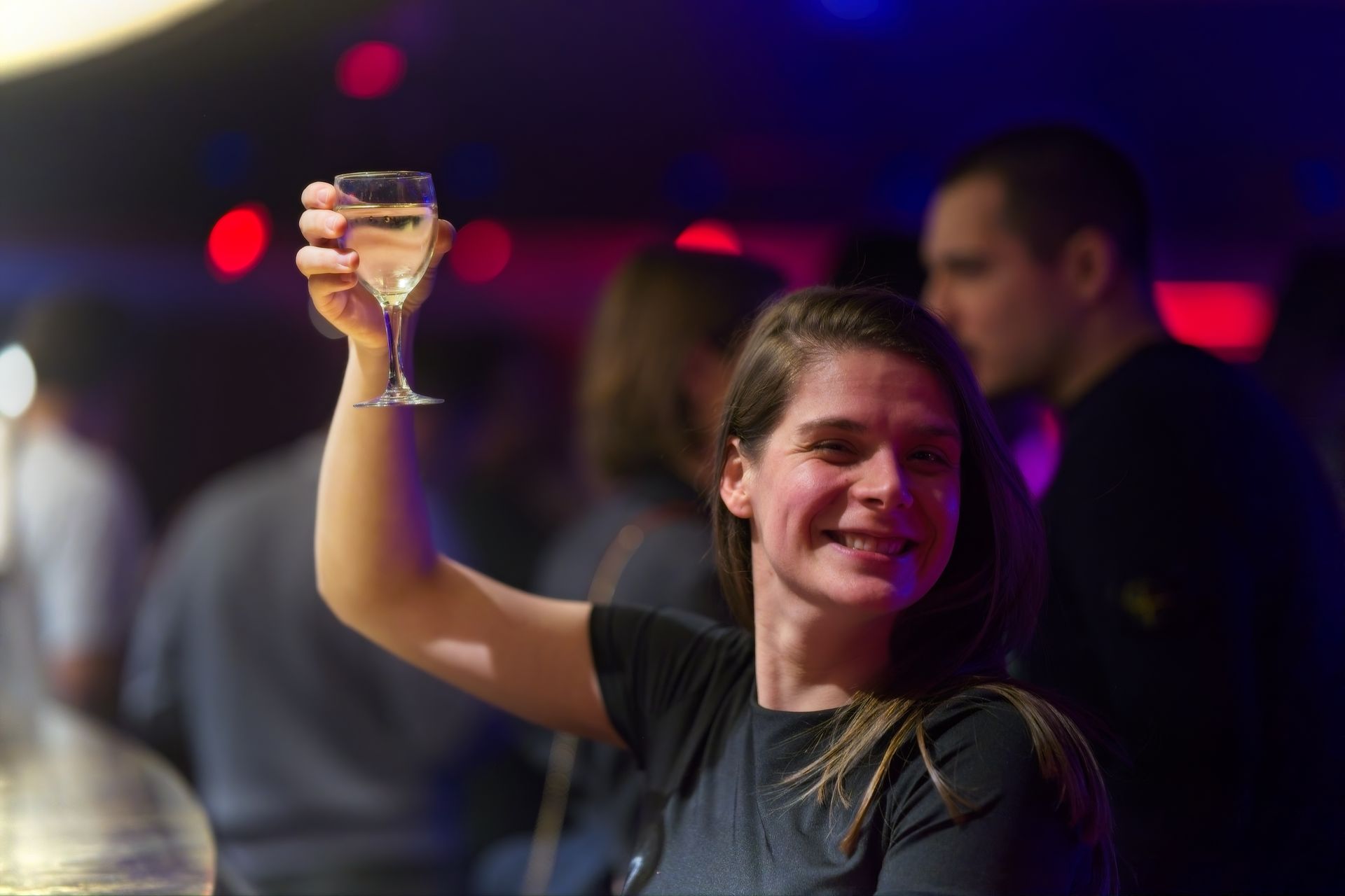 Woman raising wine glass for a toast at dinner party