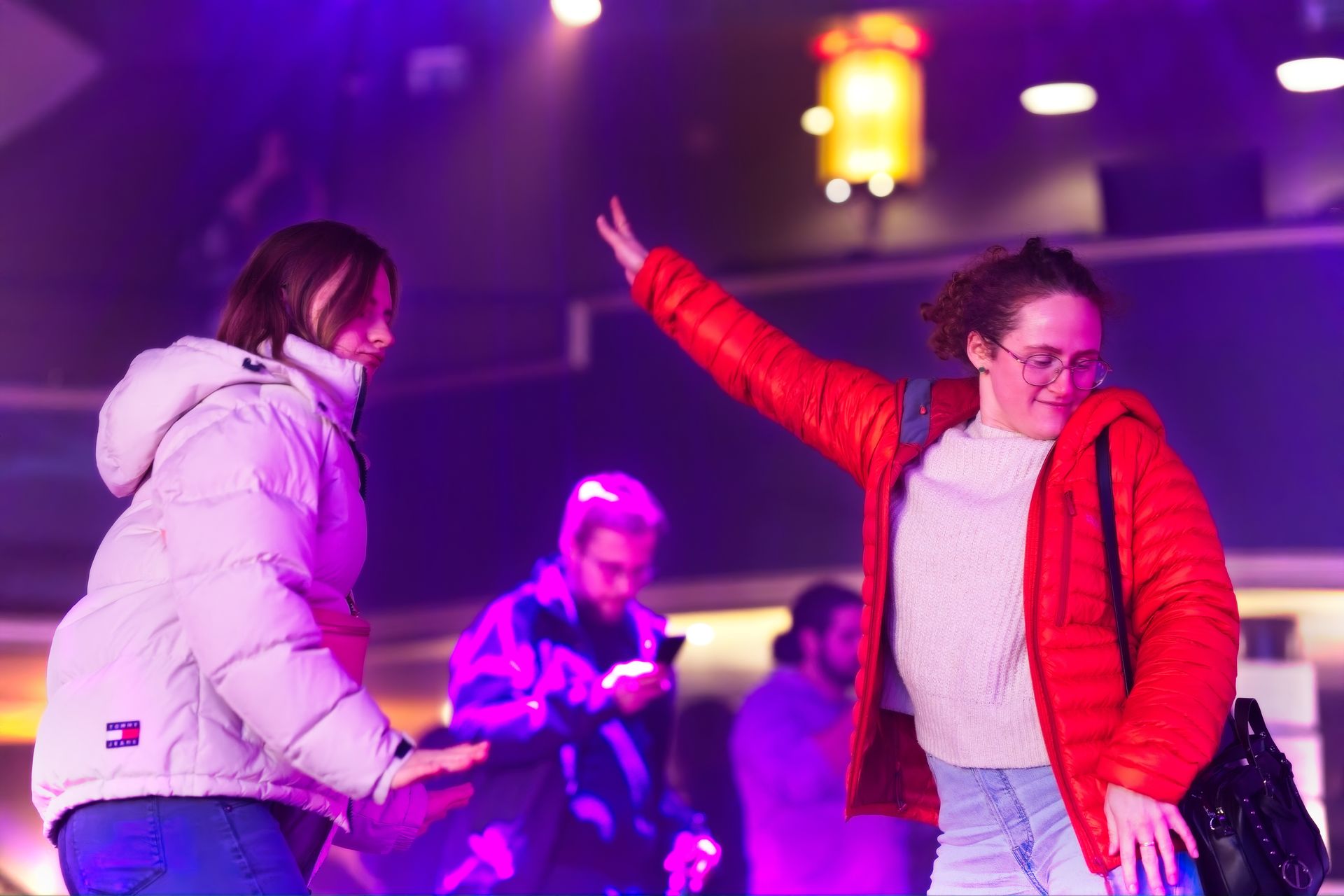 Woman in red jacket dancing at indoor event