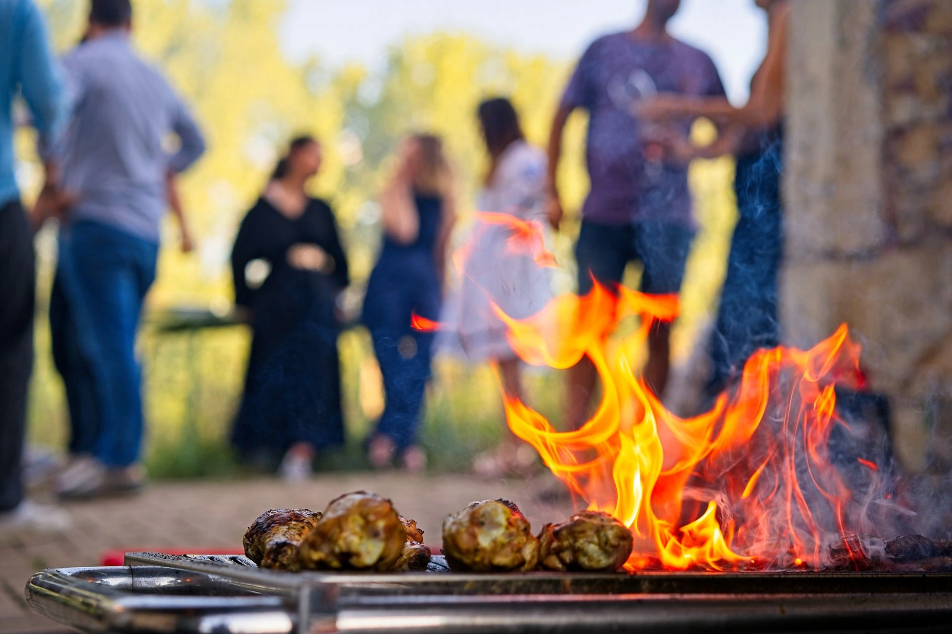 Guests gathering around BBQ station at outdoor corporate event