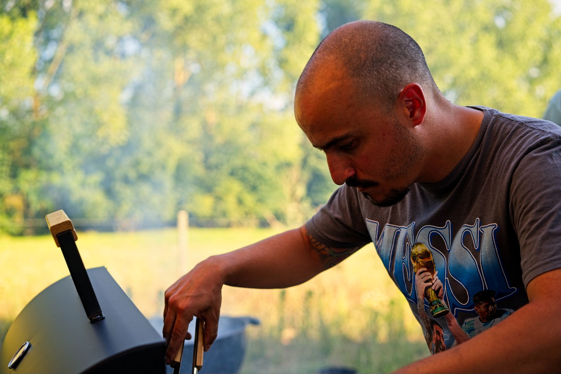Man cooking food on outdoor BBQ grill at summer party
