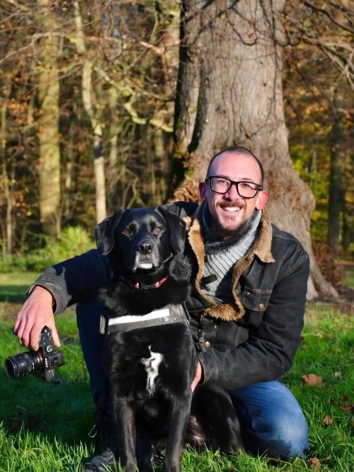 Portrait of photographer Nader Baydoun with his black labrador in a park